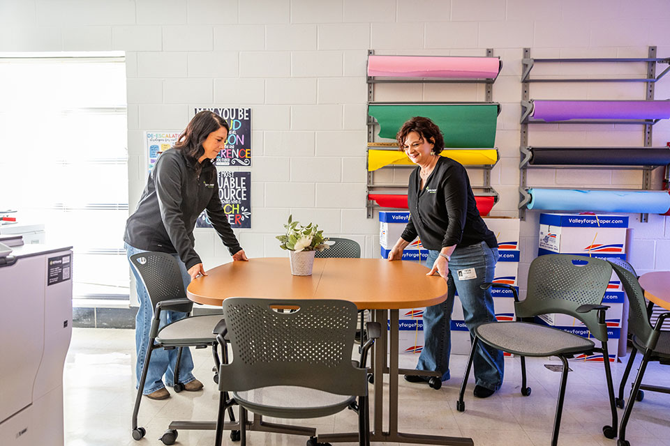 Two women moving a table