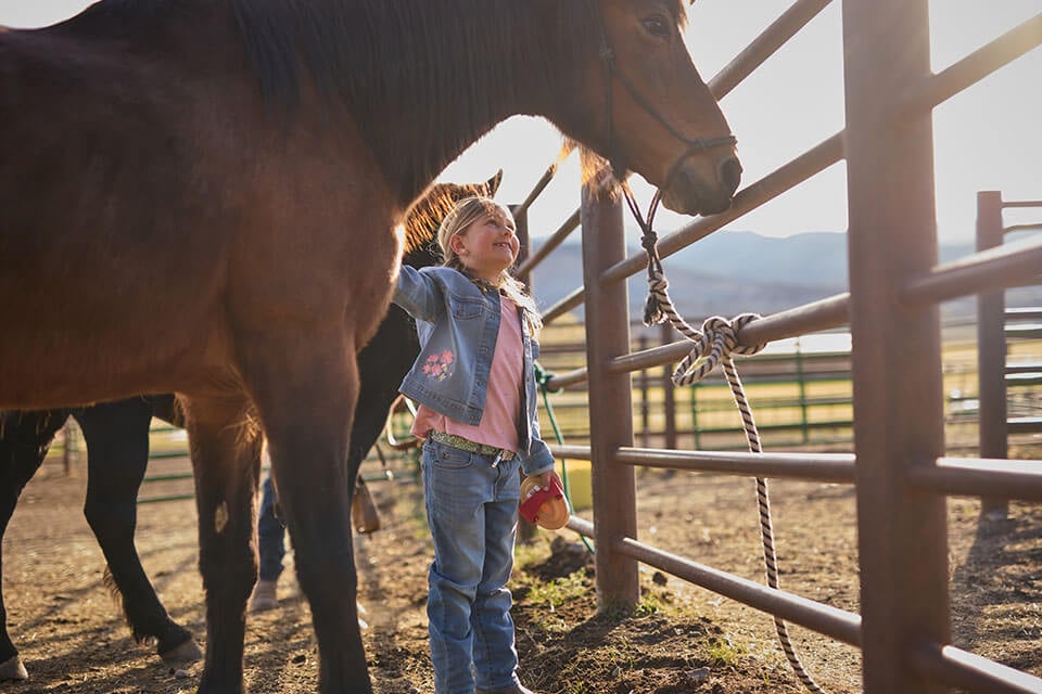 Rural1st_2025_0818_Website_BodyImage_960x640_ElieseAndRonGhaffari_FINAL Aspen Ghaffari smiles at one of her horses on the Ghaffari family property in Montrose, CO