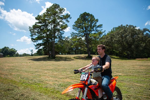 Customer and son ride dirt bike on land financed by Rural 1st.