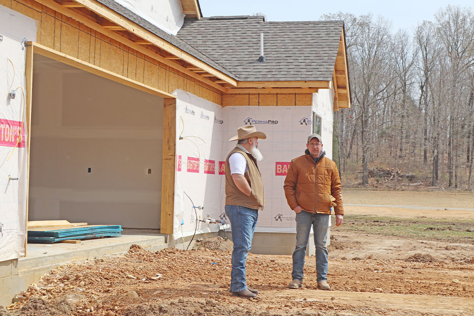 Rural 1st customer stands in front of construction site in northeast Arkansas.