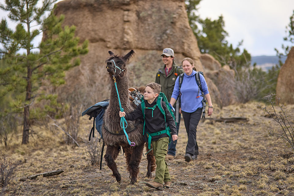 Rural1st_2026_0529_Website_StoryBodyImage_960x640_ChrisAndJenna_FINAL Rural 1st customers in Colorado hike on their rural homestead with son and llama.