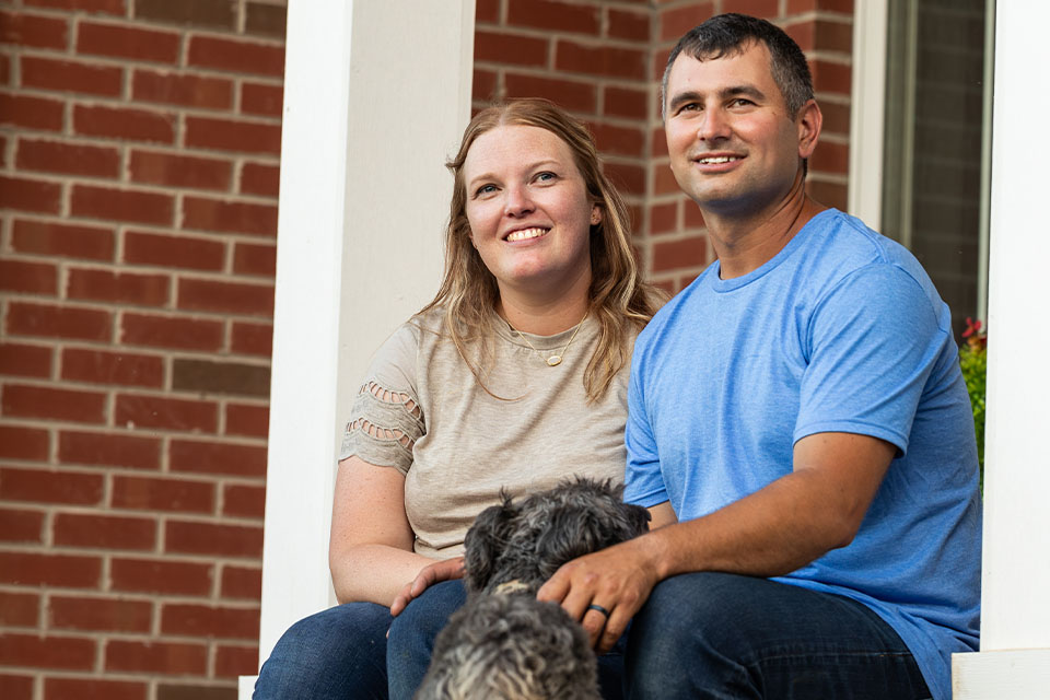 Ohio couple sit on porch of home financed through construction loan with Rural 1st