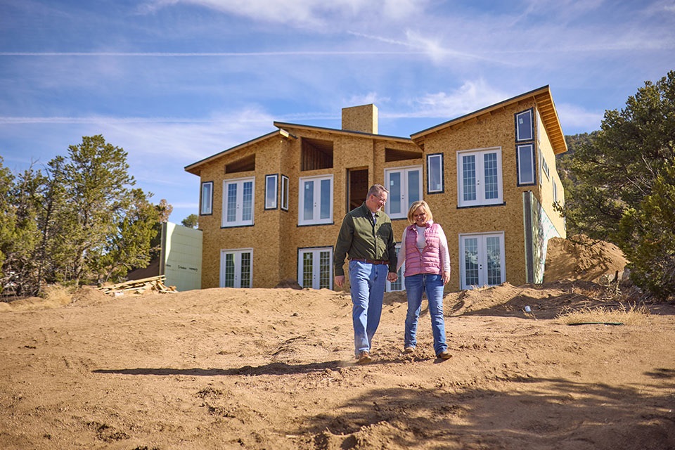 Couple walks on construction site financed by Rural 1st in rural Colorado mountains.