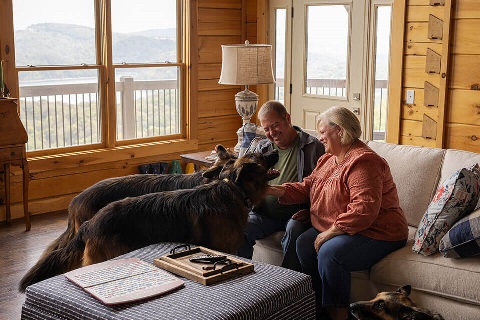Farm owners interact with dogs in vacation second home financed by Rural 1st.