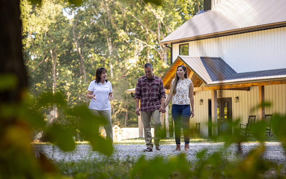 A couple talking with a Rural 1st loan officer in front of their newly constructed rural home.