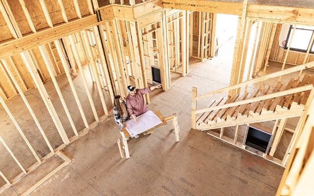 A couple admiring the building plans for their rural home during early stages of construction.