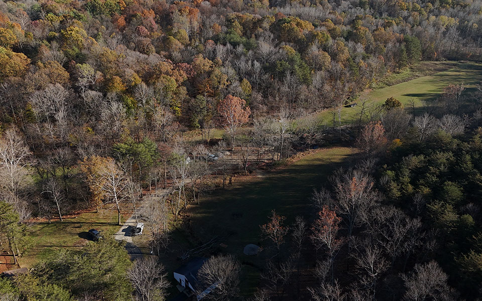 Aerial view of a wooded plot of land in the fall.