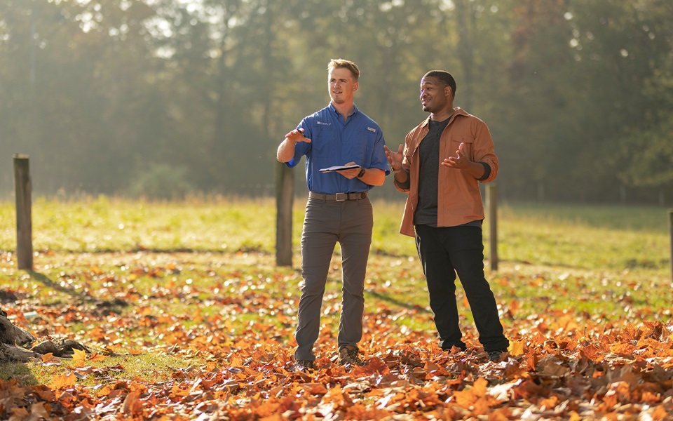 A Rural 1st loan officer chatting with a client in a rural field.