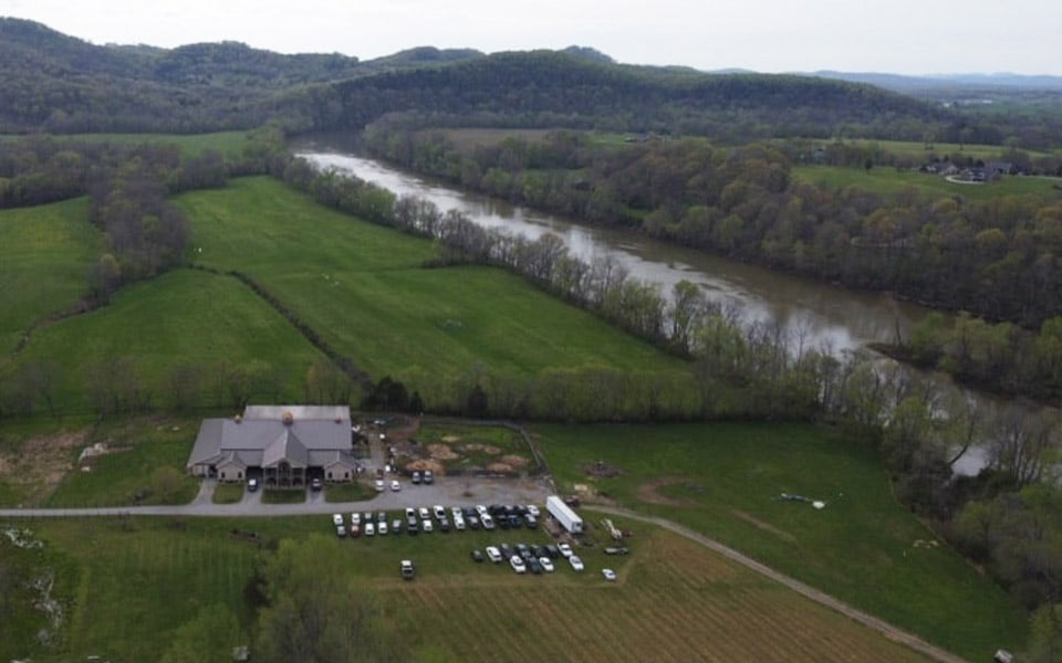 Aerial view of a newly built rural home next to a river.