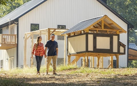 A couple holding hands and walking away from their new, rural barndo home.