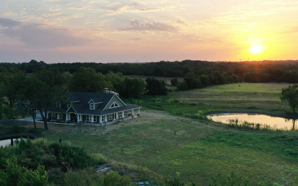 Arial view of a newly built rural home during sunset.